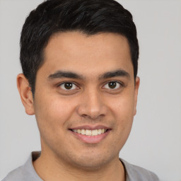 Joyful latino young-adult male with short  brown hair and brown eyes