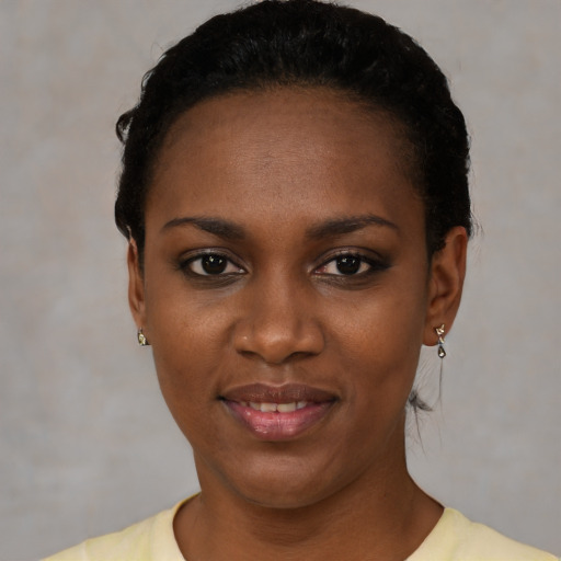 Joyful black young-adult female with short  black hair and brown eyes