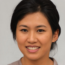 Joyful asian young-adult female with medium  brown hair and brown eyes