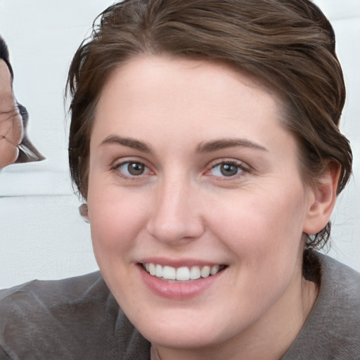 Joyful white young-adult female with medium  brown hair and blue eyes