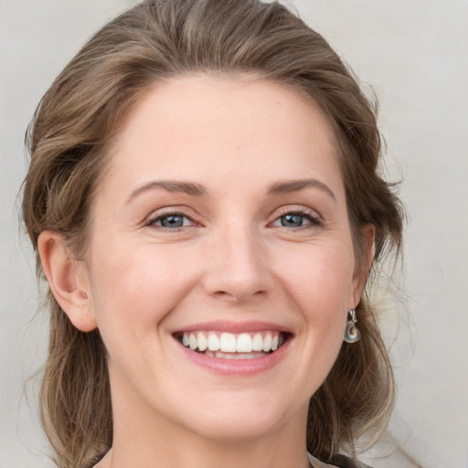 Joyful white young-adult female with medium  brown hair and green eyes