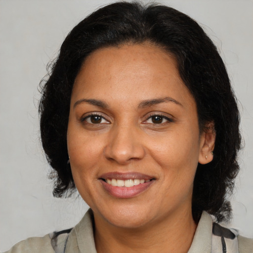 Joyful latino adult female with medium  brown hair and brown eyes