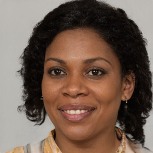 Joyful black adult female with medium  brown hair and brown eyes