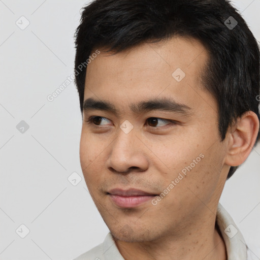 Joyful asian young-adult male with short  black hair and brown eyes