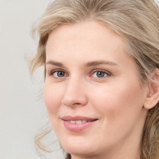 Joyful white young-adult female with medium  brown hair and blue eyes