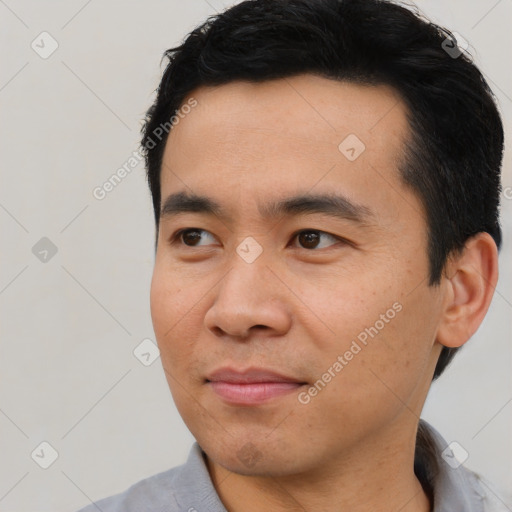 Joyful asian young-adult male with short  black hair and brown eyes