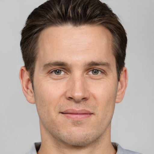 Joyful white adult male with short  brown hair and brown eyes