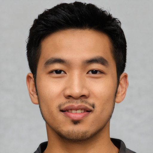 Joyful asian young-adult male with short  black hair and brown eyes