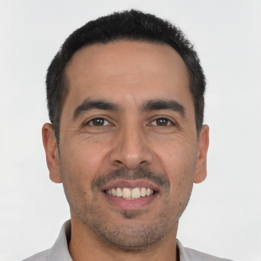 Joyful latino young-adult male with short  black hair and brown eyes