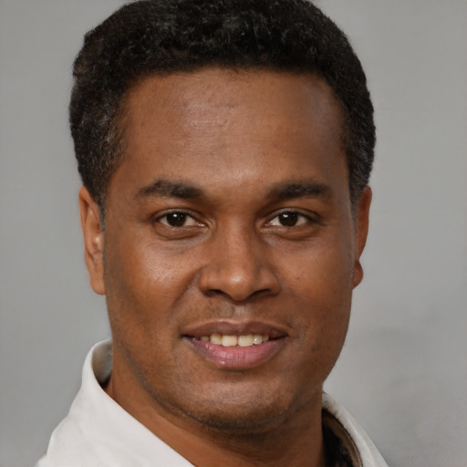 Joyful black young-adult male with short  brown hair and brown eyes
