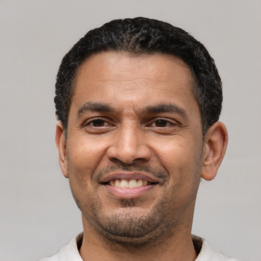 Joyful latino adult male with short  black hair and brown eyes