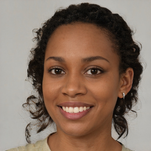 Joyful black young-adult female with medium  brown hair and brown eyes