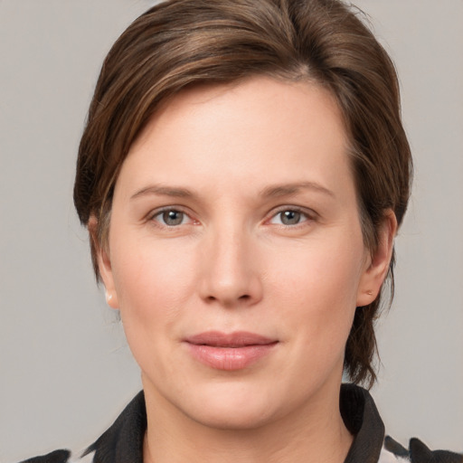 Joyful white young-adult female with medium  brown hair and grey eyes