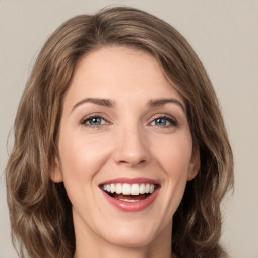 Joyful white young-adult female with long  brown hair and green eyes