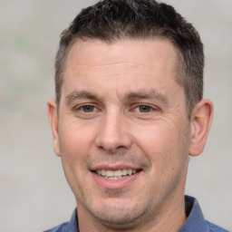 Joyful white adult male with short  brown hair and brown eyes