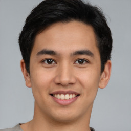 Joyful asian young-adult male with short  brown hair and brown eyes