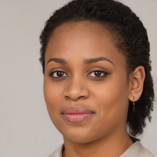 Joyful black young-adult female with long  brown hair and brown eyes