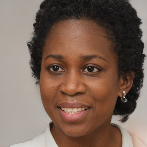 Joyful black young-adult female with short  brown hair and brown eyes