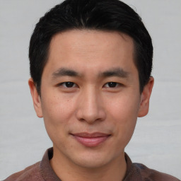 Joyful asian young-adult male with short  brown hair and brown eyes