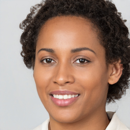 Joyful black young-adult female with medium  brown hair and brown eyes