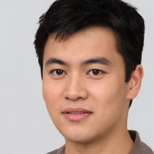 Joyful asian young-adult male with short  black hair and brown eyes