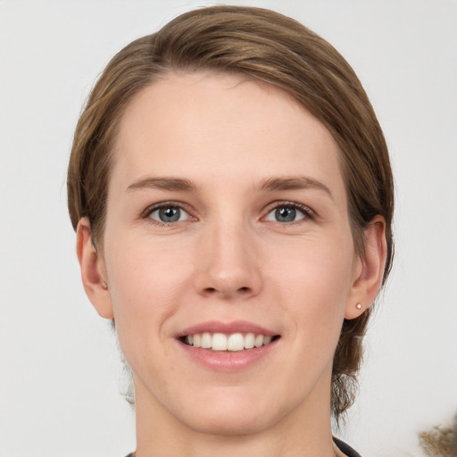 Joyful white young-adult female with medium  brown hair and grey eyes