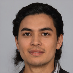Joyful latino young-adult male with short  black hair and brown eyes