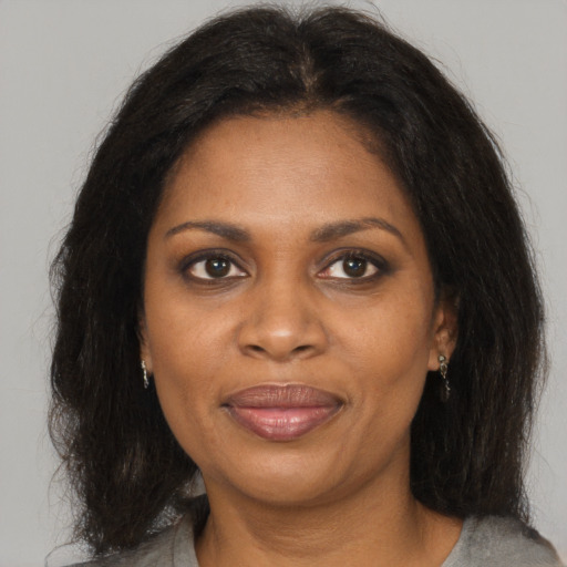 Joyful black adult female with medium  brown hair and brown eyes