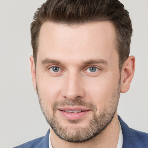 Joyful white young-adult male with short  brown hair and grey eyes