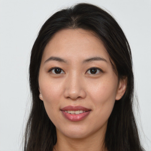 Joyful asian young-adult female with long  brown hair and brown eyes