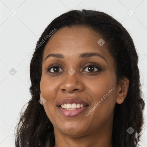 Joyful black young-adult female with long  brown hair and brown eyes