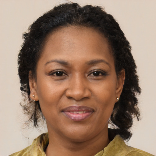 Joyful black adult female with medium  brown hair and brown eyes