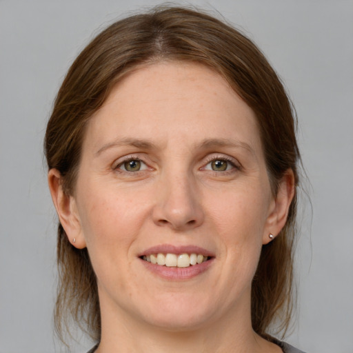 Joyful white adult female with medium  brown hair and grey eyes