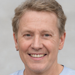 Joyful white adult male with short  brown hair and grey eyes