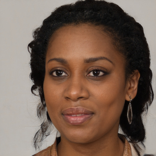 Joyful black young-adult female with long  black hair and brown eyes