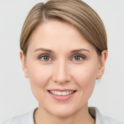 Joyful white young-adult female with short  brown hair and grey eyes