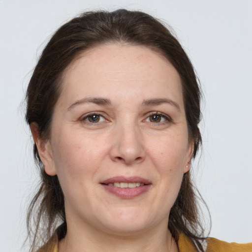 Joyful white adult female with medium  brown hair and grey eyes