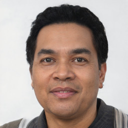 Joyful latino adult male with short  black hair and brown eyes