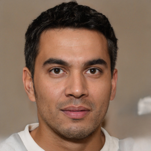 Joyful latino young-adult male with short  brown hair and brown eyes
