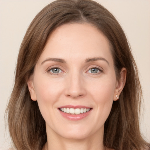 Joyful white young-adult female with long  brown hair and grey eyes