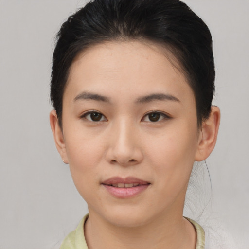 Joyful asian young-adult female with short  brown hair and brown eyes