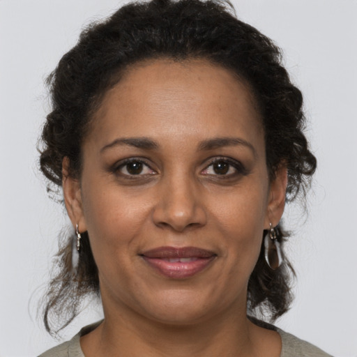 Joyful black adult female with medium  brown hair and brown eyes