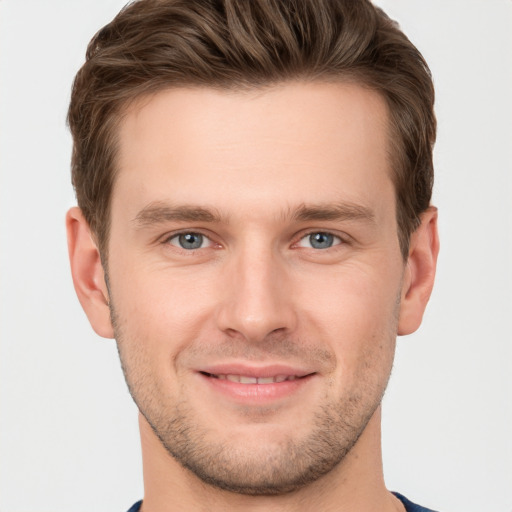 Joyful white young-adult male with short  brown hair and grey eyes