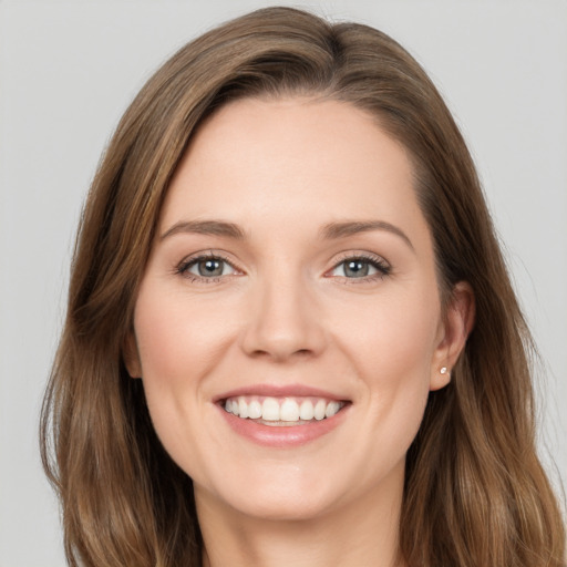 Joyful white young-adult female with long  brown hair and grey eyes