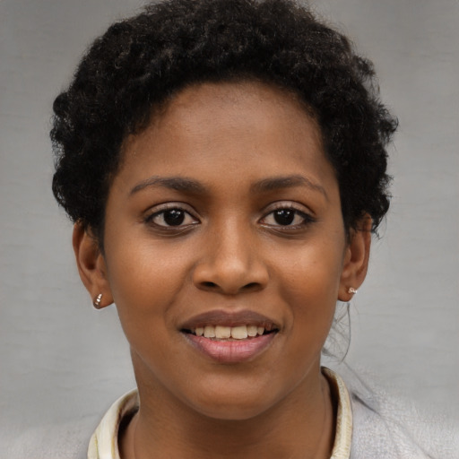 Joyful black young-adult female with short  brown hair and brown eyes