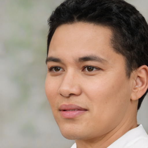 Joyful latino young-adult male with short  black hair and brown eyes