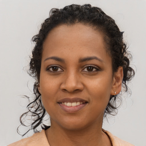 Joyful black young-adult female with short  brown hair and brown eyes