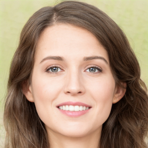 Joyful white young-adult female with long  brown hair and green eyes