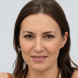 Joyful white adult female with long  brown hair and brown eyes