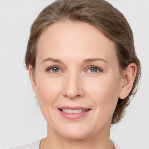 Joyful white adult female with medium  brown hair and grey eyes